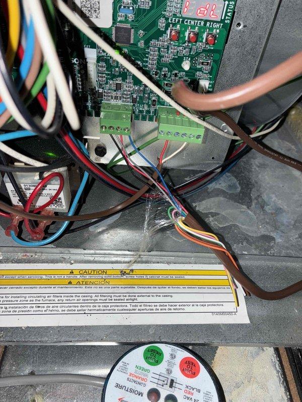 Responded to no cooling complaint on residential air conditioning system. Upon arrival, customer reported unit not producing cool air. Performed diagnostic inspection of HVAC control system and thermostat operation. Examined control board, wiring connections, and electrical components within the air handler enclosure. Verified all wire terminations at terminal blocks were secure and properly connected. Inspected PCB for any visible signs of failure or component damage. Checked thermostat display showing 78°F setpoint and confirmed communication between thermostat and system controls. All safety labels and warning indicators were noted to be present and legible on equipment.