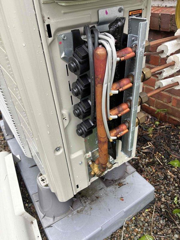 Completed first-year maintenance on MVP ductless split heat pump system. Inspected indoor wall-mounted unit and found air filter heavily clogged with accumulated dust and debris, which was cleaned to restore proper airflow. Examined outdoor condensing unit and noted copper refrigerant lines showing age-related oxidation and discoloration, though all connections remained secure and operational.