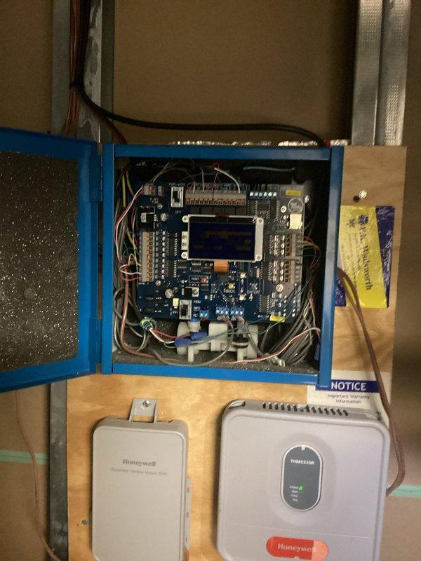 Responded to service call for unusual noise coming from circuit board in HVAC control panel. Inspected blue electrical enclosure containing zone control system with multiple circuit boards, relay modules, and associated wiring connections. Examined Honeywell zone control modules and display interfaces mounted below main panel. Verified all wire terminations were secure, checked for loose components or vibrating relays that could cause audible noise. Assessed overall system operation and confirmed proper functionality of control boards and connected devices.