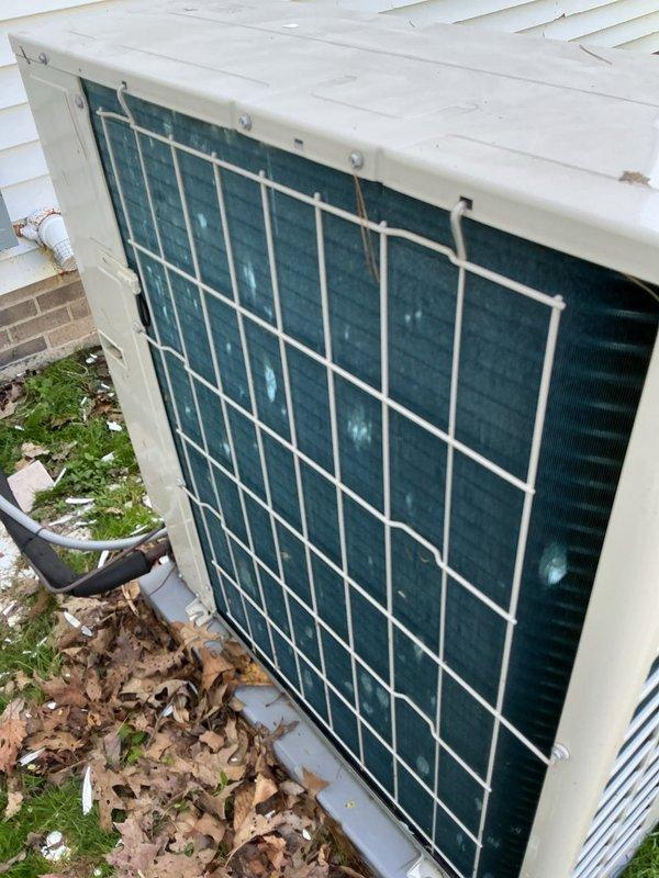 Completed cooling system tune-up on outdoor heat pump unit and documented hail damage to equipment casing and protective grille for estimate purposes. Unit operational following preventive maintenance inspection, with photographic documentation provided to customer for insurance claim processing.