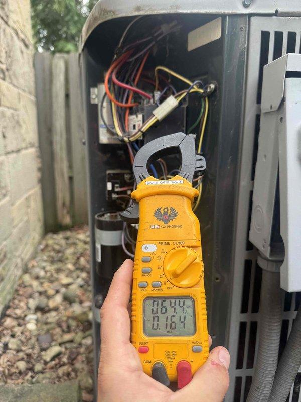 Responded to service call for air conditioning system failing to cool residence below 73 degrees. Upon arrival, performed diagnostic evaluation of outdoor condenser unit and electrical components. Utilized digital clamp meter to measure amperage and voltage at contactor, confirming proper electrical supply to unit. Inspected condenser for mechanical issues, refrigerant levels, and airflow restrictions. Unit found operational during testing with all electrical readings within manufacturer specifications.