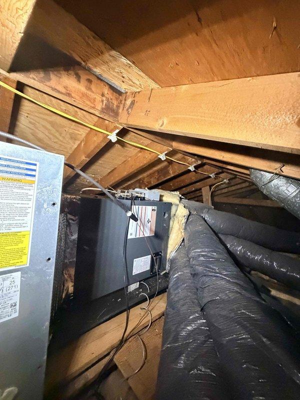 Responded to no cooling complaint on 7-month-old air handler unit installed in attic. Upon arrival, verified system was not operating when thermostat was set to cool with fan in auto mode. Performed diagnostic inspection of air handler unit, checked electrical connections, verified power supply, and inspected condensate drainage system. Documented equipment condition and attic installation with photographs showing unit placement, ductwork configuration, and insulation material.