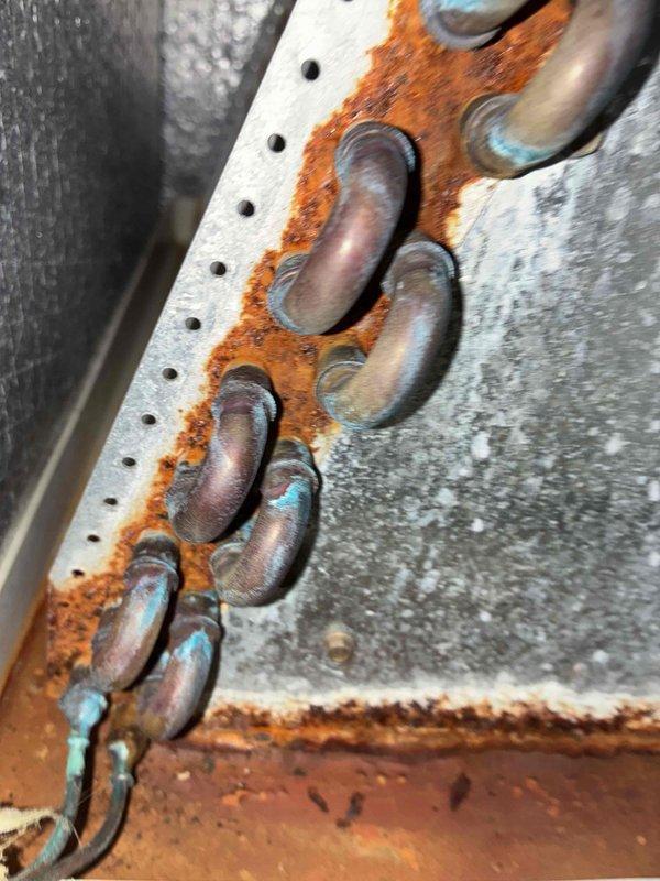 # HVAC No Heat Service Call

Responded to no heat complaint on residential furnace system over 10 years old. Upon arrival, coordinated with tenant prior to entry as requested. Conducted thorough system inspection and diagnosed heating failure. Visual assessment revealed extensive corrosion throughout critical system components, including severely rusted mounting hardware and deteriorated copper refrigerant lines showing advanced oxidation. Metal brackets and connection points exhibited significant rust penetration compromising structural integrity. Equipment displayed signs of prolonged moisture exposure and age-related deterioration consistent with end-of-life conditions. Documented existing conditions with photographic evidence showing corroded chain assembly, perforated mounting panels, galvanized ductwork surfaces, and oxidized copper piping connections with characteristic green-blue patina. System components showed wear patterns and corrosion levels indicating lack of preventative