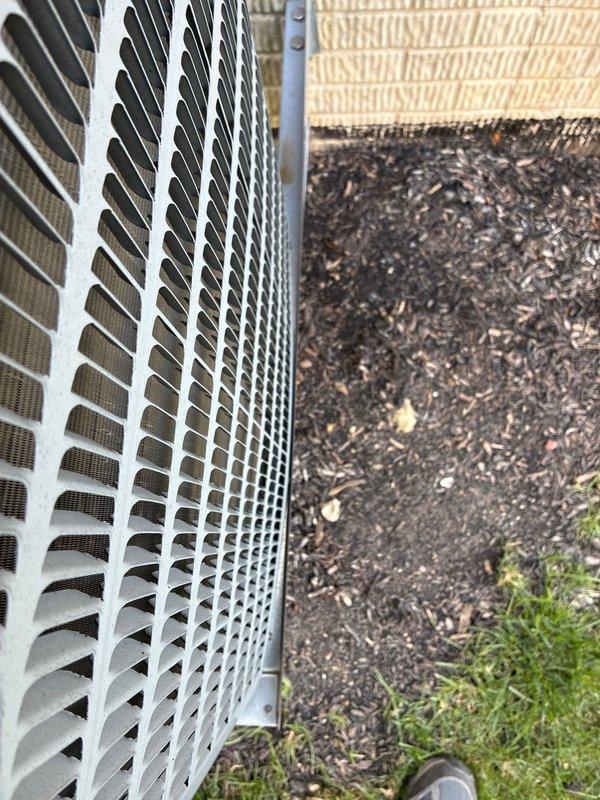 Conducted comprehensive site evaluation for complete HVAC system replacement at residential property. Documented existing exterior condensing unit with louvered metal housing positioned on ground-level mulch bed, along with electrical service infrastructure including digital meter assembly and associated conduit routing on building exterior. Provided customer with full system replacement options based on current equipment assessment and site conditions.