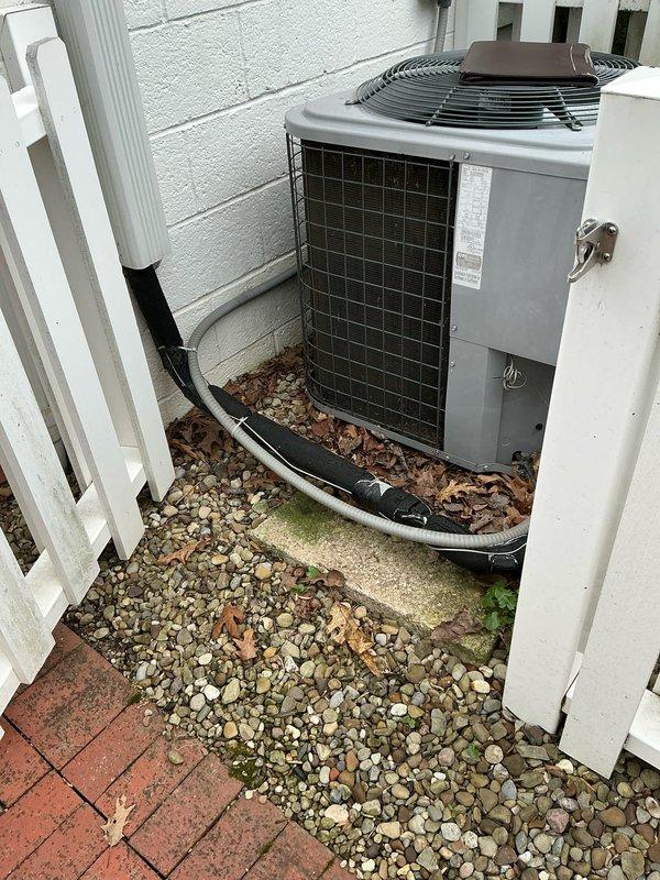 Conducted comprehensive evaluation of existing HVAC system for replacement estimate. Documented outdoor condensing unit positioned against exterior wall with refrigerant lines running along ground through landscaping area. Assessed indoor air handler unit installed in attic space, noting ComfortMaker equipment with accessible filter location marked on cabinet. Photographed both components to provide visual documentation of current system configuration, equipment condition, and installation environment for replacement options analysis.