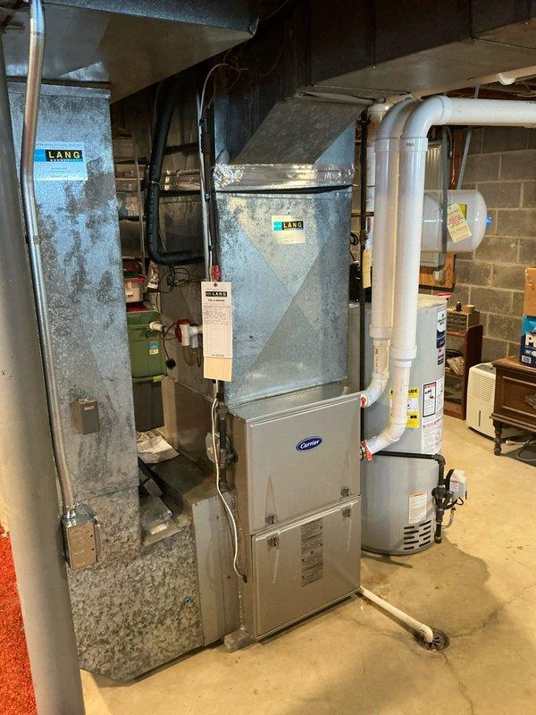 Provided AC replacement estimate for hail-damaged unit in residential basement setting with existing Carrier furnace system. Documented current equipment condition and HVAC infrastructure including ductwork, condensate drainage system, and associated components for insurance claim submission.