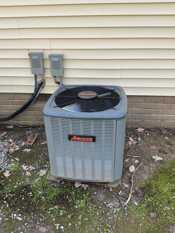 # HVAC Maintenance Service Completed

Performed comprehensive annual preventive maintenance on residential split-system air conditioning equipment as part of scheduled service plan agreement. 

**Outdoor Unit Inspection:**
Conducted thorough inspection of Amana brand condenser unit located on exterior concrete pad. Verified proper operation of condenser fan motor and assessed overall unit condition. Inspected electrical disconnect boxes and conduit connections for secure mounting and proper weatherproofing. Noted accumulation of organic debris, moss growth, and weathering on concrete pad and surrounding area. Cleared debris from base of unit and immediate perimeter to ensure adequate airflow and prevent potential blockages to coil surfaces.

**Indoor Unit Inspection:**
Accessed furnace and air handler equipment in mechanical closet. Inspected blower assembly, filter condition, and ductwork connections. Verified proper installation and condition of flexible supply ductwork with insulati