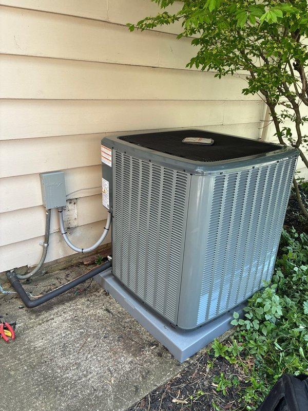Completed full HVAC system installation including new air conditioning condenser unit, air scrubber, humidifier, and return drop. Condenser unit was positioned on composite pad against exterior wall with proper clearance for airflow and maintenance access. Installed weatherproof electrical disconnect box on exterior siding with conduit connections to unit. Ran and insulated refrigerant lines from condenser to indoor air handler. System was charged, tested, and verified operational. Installation financed through Greensky.