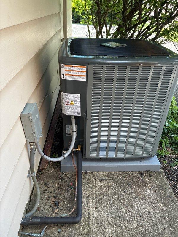 Completed full HVAC system installation including new air conditioning condenser unit, air scrubber, humidifier, and return drop. Condenser unit was positioned on composite pad against exterior wall with proper clearance for airflow and maintenance access. Installed weatherproof electrical disconnect box on exterior siding with conduit connections to unit. Ran and insulated refrigerant lines from condenser to indoor air handler. System was charged, tested, and verified operational. Installation financed through Greensky.