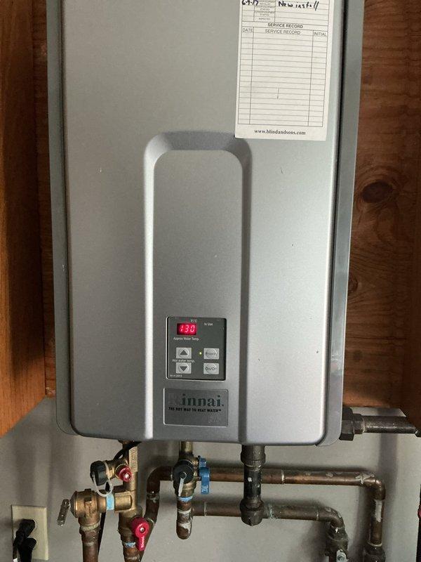 Completed comprehensive cooling system maintenance and performed full service on Rinnai tankless water heater unit. Inspected and verified proper operation of digital controls displaying 430°F setpoint, checked all plumbing connections including copper lines and shut-off valves with proper hot/cold identification, and examined P-trap assembly and drainage components beneath unit for proper function and leak-free operation.