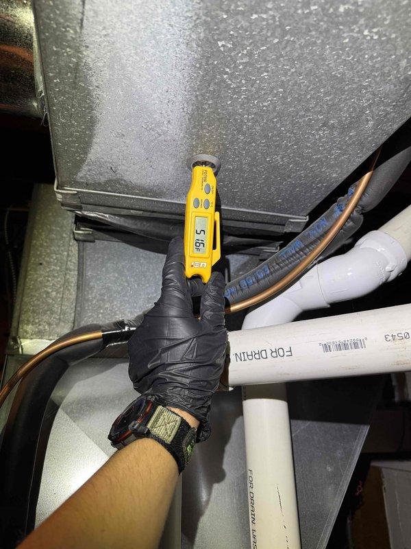 Completed preventative maintenance service on two HVAC cooling systems. Performed thorough inspection of outdoor condenser unit, accessing internal components to evaluate evaporator coil condition, refrigerant line integrity, and overall system operation. Observed moderate dust and debris accumulation on coil fins with some surface oxidation consistent with normal outdoor exposure. Checked refrigerant lines and insulation for wear and proper installation. Evaluated indoor air handler unit, noting active condensation on exterior surfaces indicating normal system operation during cooling mode. Measured temperature differential across system components using digital diagnostic equipment to verify proper cooling performance. Cleared debris from base of outdoor unit and documented system conditions through photographic records for maintenance history.