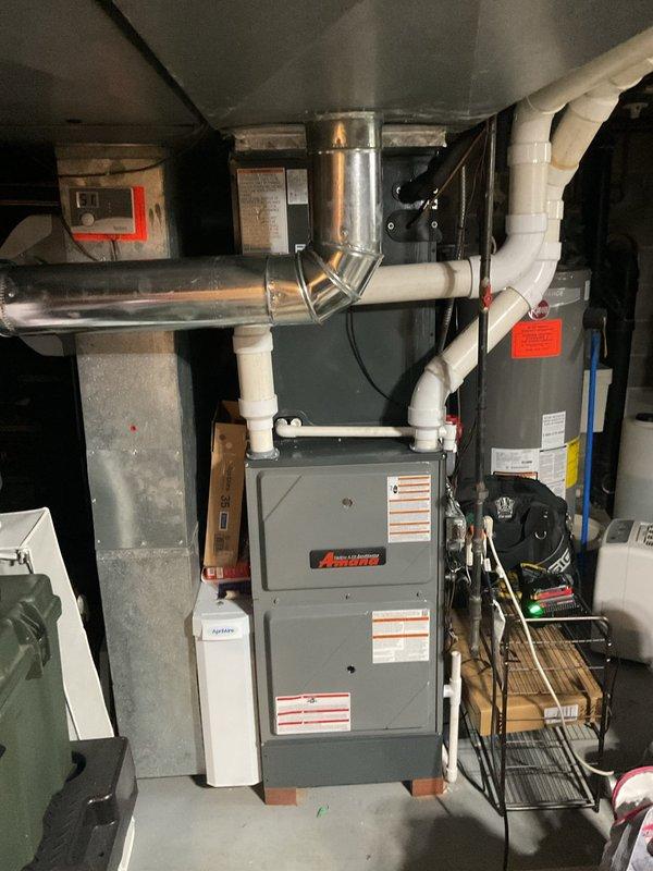 Performed comprehensive preventive maintenance on residential HVAC cooling system located in basement mechanical room. Inspected gray furnace unit with associated white PVC condensate piping and metal flue vent connections, verifying all joints and elbows for proper sealing and drainage. Evaluated ductwork system including galvanized metal supply and return runs, confirming structural integrity and identifying minor dust accumulation. Utilized Fieldpiece diagnostic equipment to measure system performance parameters and verify operational efficiency. All equipment found to be in satisfactory working condition with no immediate repairs required.