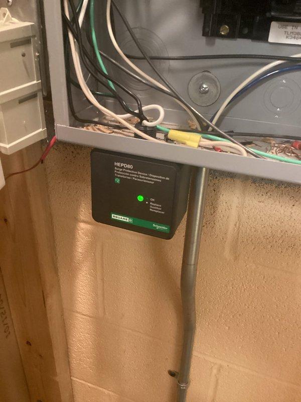 Installed a Schneider Electric HEPD80 whole home surge protection device to safeguard the residential electrical system from voltage spikes and power surges. The unit was hardwired into the main electrical panel, with proper connections made to the service entrance conductors and grounding system, and is now actively protecting all downstream circuits as indicated by the green operational status light.