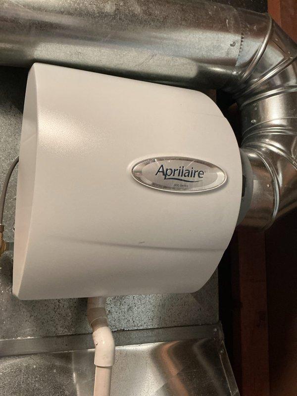 Completed scheduled cooling system maintenance on outdoor condensing unit and associated indoor components. Inspected Aprilaire humidifier installation, verified proper mounting and water supply line connection to ductwork system. Examined outdoor unit refrigerant lines, service valves, and connection points; noted normal weathering on exterior components with all piping properly secured and insulated.