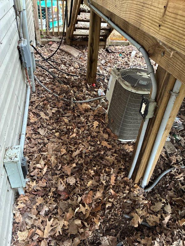 Conducted comprehensive HVAC system replacement estimate for residential property. Evaluated existing outdoor condensing unit located in under-deck crawlspace area with significant leaf debris accumulation around equipment, assessed accessibility challenges due to wooden structural supports and confined workspace. Documented interior measurements of existing system components and examined door frame clearances for equipment removal and new installation access. Presented multiple air conditioning replacement options and discussed complete system configuration alternatives with property owner.