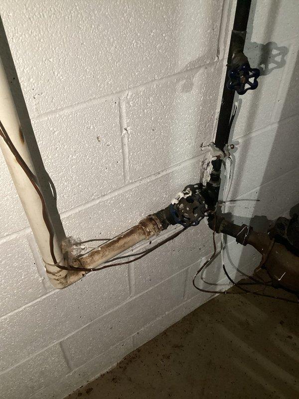 Responded to a service call for a heavily leaking 8-inch pipe connected to an outdoor spigot in the backyard. Upon inspection, identified significant corrosion and rust buildup on the horizontal supply line, with visible rust staining and active water discharge at the connection point. Accessed the plumbing infrastructure from the crawl space beneath the floor joists to assess the full extent of the leak and pipe deterioration. Documented the corroded pipe sections and compromised fittings showing heavy oxidation that had caused the failure in the outdoor spigot supply line.