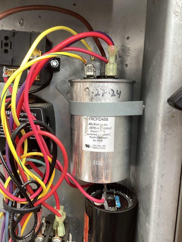 Completed comprehensive cooling system maintenance on 6-year-old unit per contract specifications. Performed detailed inspection of outdoor condenser unit, noting significant debris accumulation around base and sides that was cleared to ensure proper airflow and system efficiency. Inspected electrical components including dual-run capacitor (TRCFD455, 45+5µF, 370VAC) which tested within normal operating parameters. Verified all wire connections secure, checked refrigerant line valves for proper operation, and confirmed unit operating at manufacturer specifications. System returned to normal service with no deficiencies noted.