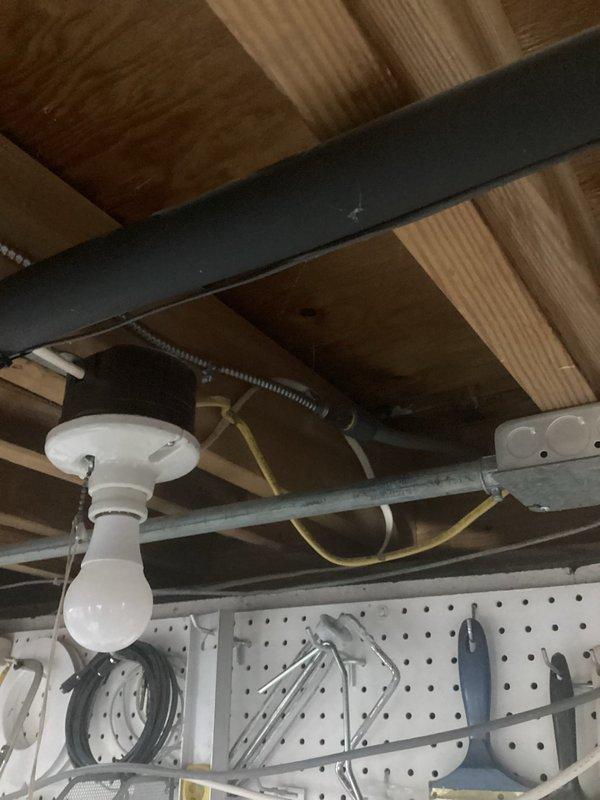 Ran new electrical circuit from existing service panel with breaker modifications to supply power to workshop area. Installation included routing cable through finished spaces, installing junction box with appropriate circuit protection, and mounting new lighting fixture with pegboard work area. Exterior electrical panel was accessed and modified to accommodate additional circuit load, with proper conduit installation and wire terminations completed per code requirements.