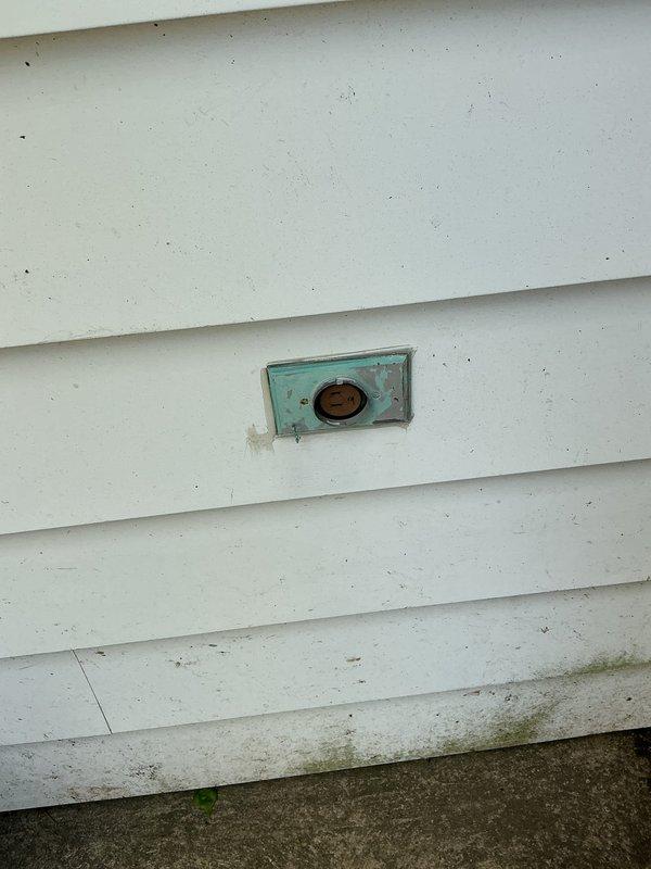 Provided estimate for electrical repairs including installation of one exterior GFCI outlet, replacement of non-GFCI bathroom outlet with code-compliant GFCI protection, and repair of loose living room receptacle. Inspected existing bathroom outlet on light blue wall near vanity sink and assessed weathered exterior outlet box with corroded turquoise cover on white vinyl siding showing signs of moisture exposure and age-related deterioration. Documented current conditions of electrical fixtures requiring upgrade to meet safety standards and resolve connection issues.