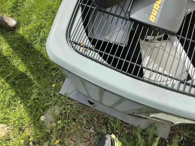 Responded to rental property for air conditioning replacement estimate following storm damage to existing outdoor condenser unit. Assessed damaged forced air cooling system, documented current equipment condition including compromised condenser housing and electrical connections, photographed unit positioning on pad with overgrown vegetation, and evaluated electrical disconnect and line set routing along building exterior. Provided homeowner with replacement options for complete system installation.