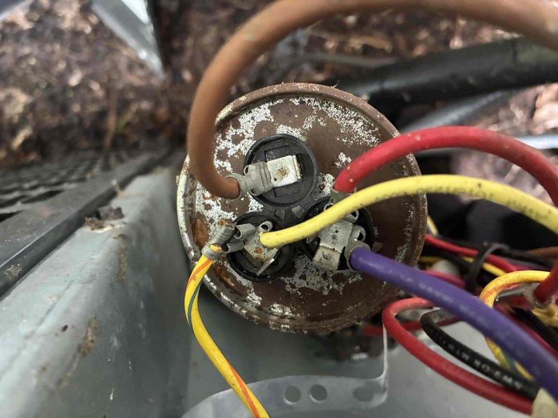 Completed comprehensive HVAC maintenance on heating and cooling systems, along with hot water tank servicing. Inspection revealed significant corrosion on outdoor unit capacitor and associated electrical connections, with visible weathering on condenser components from environmental exposure. Documented water damage and staining around plumbing penetration point, indicating previous or ongoing moisture intrusion requiring monitoring.