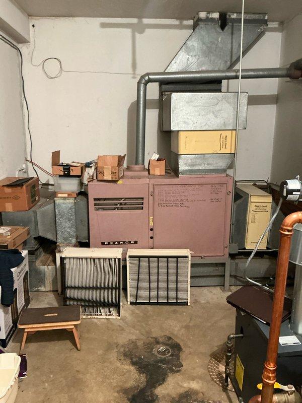 Removed existing non-functional Reznor heating unit from basement mechanical room and installed new dual-zone air handler and air conditioning system with new air filter racks. Portions of the HVAC system were installed in the crawlspace, requiring coordination between basement and crawlspace areas to ensure proper ductwork connections and system integration. The replacement addresses the failed existing AC system and upgrades the home to a more efficient dual-zone comfort control solution.