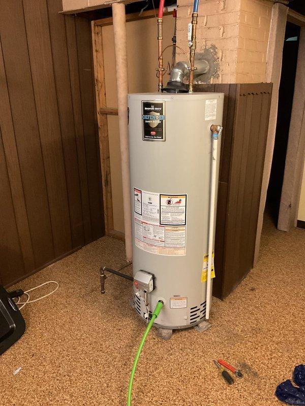 Performed routine maintenance flush on a Bradford White 50-gallon natural gas tanked water heater (Model RG250S6N) installed in basement utility area. Drained sediment and mineral buildup from tank bottom through drain valve to restore heating efficiency and extend equipment lifespan. Inspected unit condition, verified proper operation of gas control valve and temperature-pressure relief valve, and confirmed all plumbing connections and PEX supply lines remained secure with no signs of leakage. Unit returned to normal operation following flush procedure.