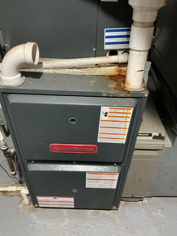 Completed comprehensive cooling system tune-up on Goodman HVAC unit. Performed standard maintenance inspection of furnace and air handler components, documenting existing rust staining on top panel indicating previous moisture exposure and age-related wear on PVC condensate drainage system with visible discoloration at pipe joints. All accessible equipment photographed and system evaluated for proper operation ahead of cooling season.
