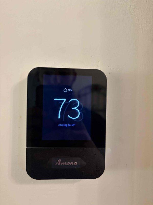 Conducted warranty inspection of newly installed Amana HVAC system. Verified proper operation of digital thermostat displaying cooling mode with accurate temperature and humidity readings, and inspected control board assembly confirming all electrical connections, wire terminations, and circuit board components are secure and functioning correctly.
