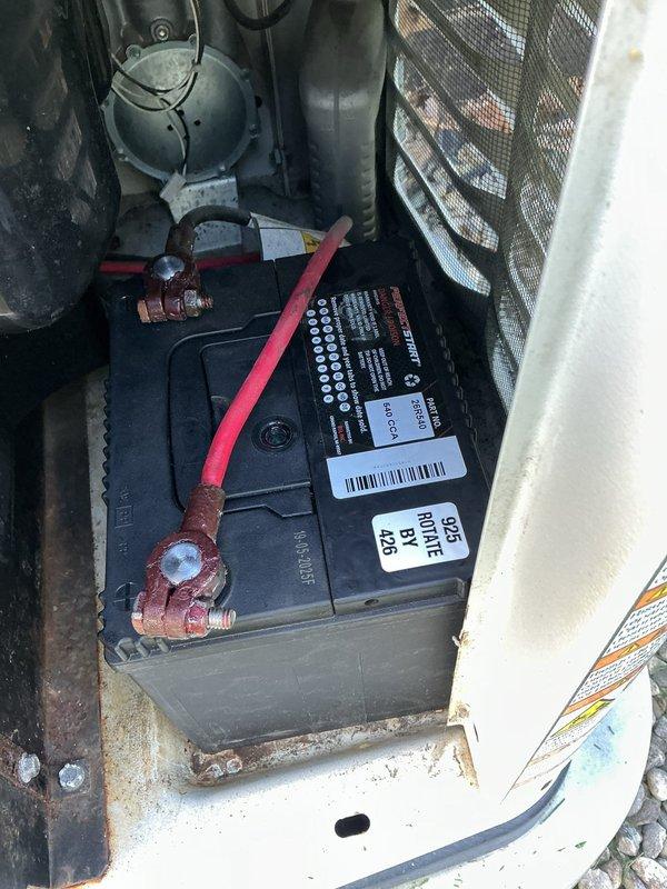 Responded to service call for Generac Guardian Series standby generator displaying red fault light and failure to operate following power outage and surge event. Upon arrival, performed visual inspection of unit and internal components. Identified severe corrosion on battery terminals and cable connections, which prevented proper electrical contact and system startup. Cleaned battery terminals and cable ends, removing corrosion buildup. Tested battery voltage and charging system operation. Verified all mechanical components, engine systems, and control board for surge damage. Reset fault codes and conducted operational test to confirm generator functionality restored. Unit returned to normal standby mode with no fault indicators present.