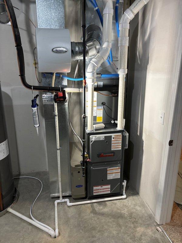 Completed full HVAC system installation including high-efficiency 96% AFUE furnace and air conditioning unit with matching evaporator coil. Installed Aprilaire humidifier for whole-home humidity control, routed refrigerant lines with proper insulation, and configured PVC venting system for condensate drainage and exhaust. All ductwork connections secured, system tested and operational.