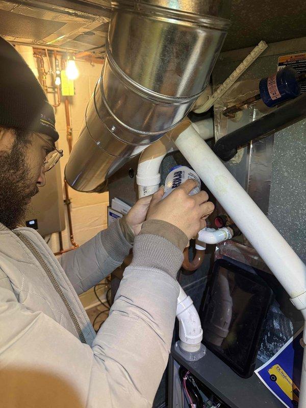 Completed scheduled preventive maintenance on residential cooling system. Performed inspection and servicing of indoor air handler components including condensate drain lines and PVC piping connections in basement mechanical room. Conducted outdoor condenser unit diagnostics using clamp meter to verify proper electrical draw and compressor amperage on Samsung unit, confirming system operating within manufacturer specifications.