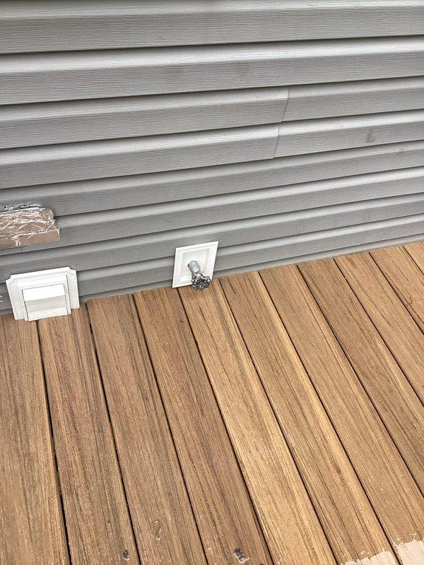 Performed site assessment for outdoor spigot relocation on residential property. Evaluated existing spigot location on exterior wall near deck area and inspected interior plumbing routing through utility space to determine feasibility and provide relocation quote. Documented current installation configuration including exterior siding penetration point and interior supply line path along ceiling infrastructure.