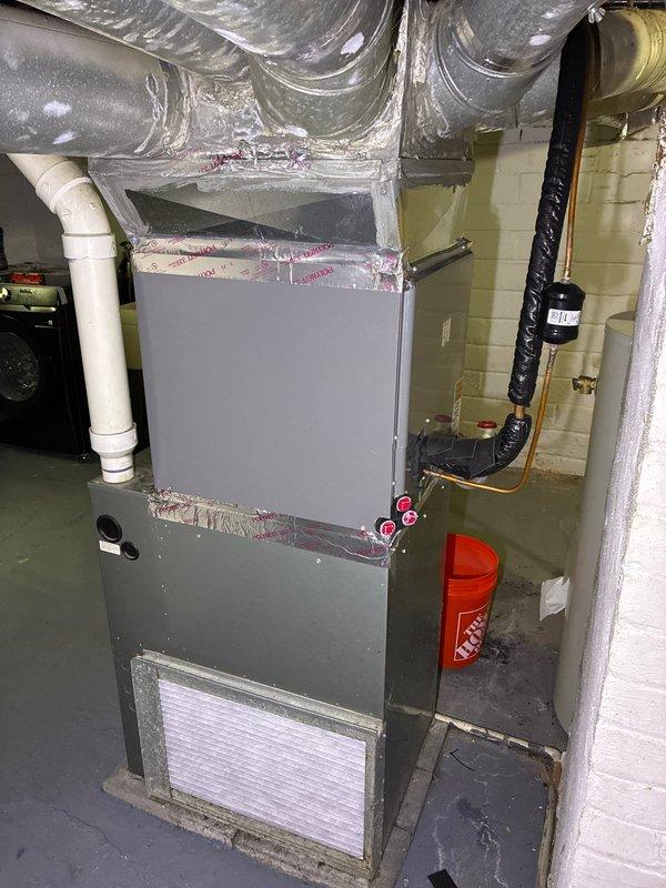 Completed comprehensive HVAC system evaluation for furnace replacement estimate in residential basement mechanical room. Assessed existing gray metal forced-air furnace with visible air filtration system, ductwork connections, and associated PVC condensate drainage piping. Documented current equipment configuration including Bradford White water heater, flexible ductwork distribution system, refrigerant line connections with brass fittings, and overall mechanical room layout. Provided homeowner with furnace replacement options while noting that existing air conditioning system is newer and in serviceable condition, allowing for furnace-only replacement to optimize cost-effectiveness while maintaining functional cooling equipment.