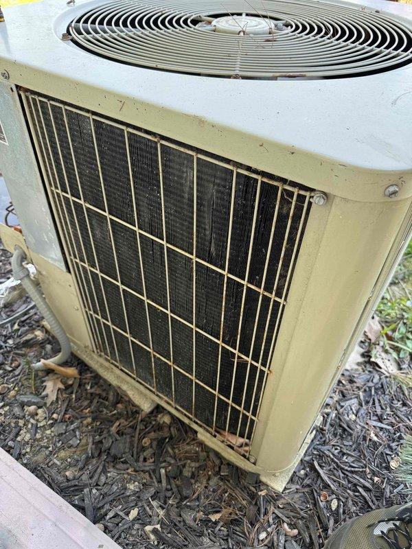 Performed diagnostic evaluation on 1994 residential air conditioning condenser unit following reported hail damage to condenser fins. Inspected outdoor condensing unit, assessed condition of protective grille, condenser coils, and fan assembly. Unit exhibited significant age-related wear and weathering consistent with 30+ year operational lifespan. Documented current equipment condition through photographic documentation showing intact cabinet structure, operational fan grille assembly, and accessible condenser coils behind protective metal grille. Evaluated feasibility of condenser fin repair versus full system replacement based on equipment age, overall condition, and extent of damage. Provided assessment findings for insurance claim documentation and replacement estimate preparation.