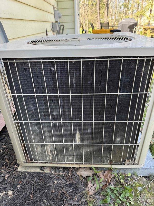 Performed diagnostic evaluation on 1994 residential air conditioning condenser unit following reported hail damage to condenser fins. Inspected outdoor condensing unit, assessed condition of protective grille, condenser coils, and fan assembly. Unit exhibited significant age-related wear and weathering consistent with 30+ year operational lifespan. Documented current equipment condition through photographic documentation showing intact cabinet structure, operational fan grille assembly, and accessible condenser coils behind protective metal grille. Evaluated feasibility of condenser fin repair versus full system replacement based on equipment age, overall condition, and extent of damage. Provided assessment findings for insurance claim documentation and replacement estimate preparation.