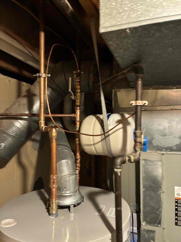 Completed installation of 50-gallon Bradford White residential water heater in basement utility area. Removed existing unit and installed new water heater with proper copper supply line connections, expansion tank, pressure relief valve assembly, and all required safety components per manufacturer specifications and local plumbing codes. Verified all connections for proper operation and tested system for leaks.