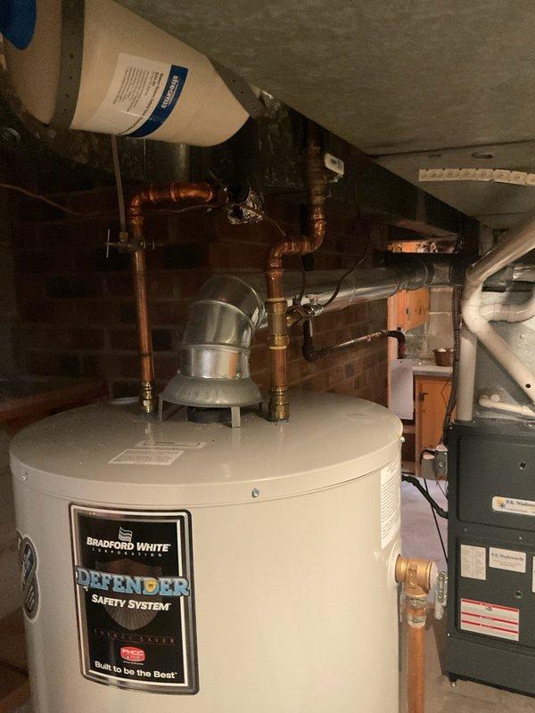 Performed routine maintenance on residential water heating system, completing a full flush and fill procedure on the Bradford White water heater unit. Drained sediment buildup from tank using drain valve, refilled system, and verified proper operation of all components including pressure relief valve and gas control assembly.