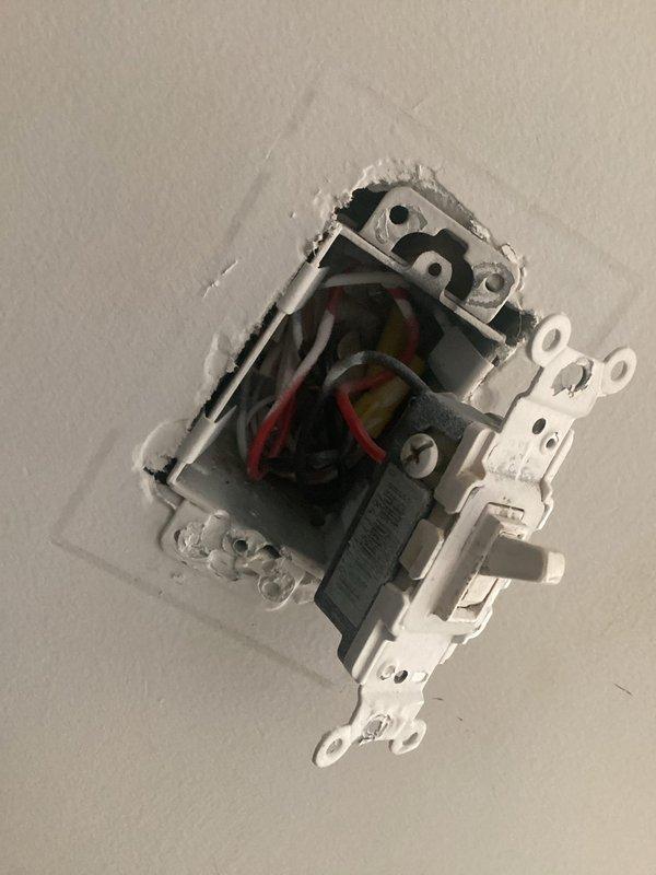 Conducted electrical inspection of bedroom to assess feasibility of installing additional outlets. Examined existing outlet configuration, removed cover plate and partially extracted receptacle to evaluate wiring setup and available circuits. Documented current electrical box conditions, wire connections (including black, red, and white conductors), and wall cavity access for pricing estimate on new outlet installation.