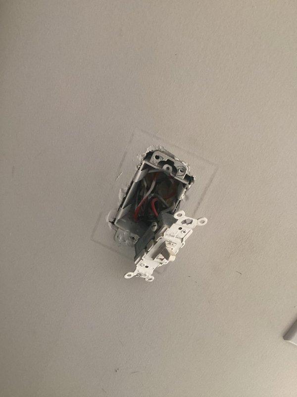 Conducted electrical inspection of bedroom to assess feasibility of installing additional outlets. Examined existing outlet configuration, removed cover plate and partially extracted receptacle to evaluate wiring setup and available circuits. Documented current electrical box conditions, wire connections (including black, red, and white conductors), and wall cavity access for pricing estimate on new outlet installation.