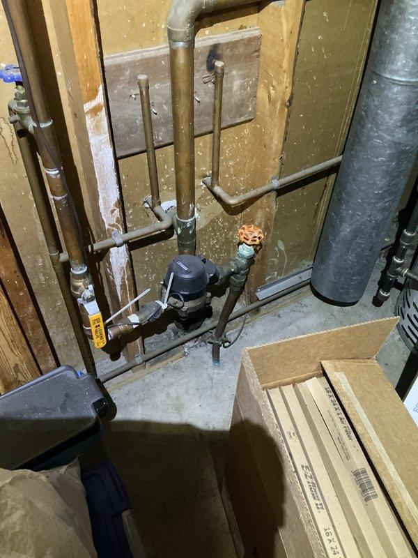 Conducted electrical inspection for reported porch light malfunction. Documented electrical panel configuration showing two rows of circuit breakers with multiple wire connections entering from top and sides, noting disorganized wiring throughout panel cavity. Also photographed basement mechanical systems including circulation pump and associated plumbing infrastructure for comprehensive site assessment.