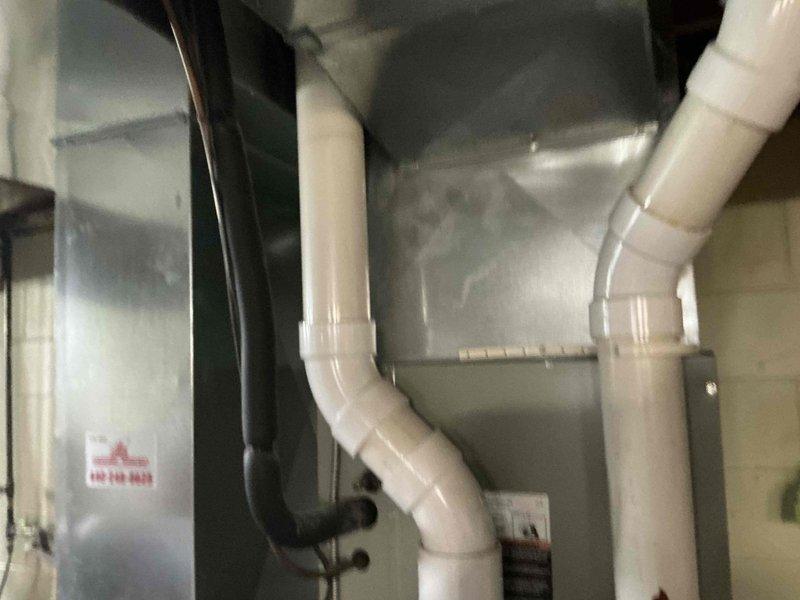 Completed comprehensive evaluation of existing residential HVAC system for full replacement estimate. Assessed outdoor condensing unit positioned on concrete pad adjacent to structure, noting current equipment configuration and installation parameters. Inspected indoor air handler components including existing PVC condensate drainage system and ventilation piping. Documented current system layout, equipment specifications, and spatial constraints to provide accurate replacement options for complete heating and cooling system upgrade.