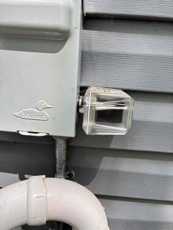 Completed scheduled cooling system maintenance on residential HVAC unit. Inspected exterior condenser disconnect box, refrigerant line connections, and condensate drain system. All components operating within normal parameters, copper refrigerant lines and PVC drainage showing proper installation and no signs of leakage or deterioration.