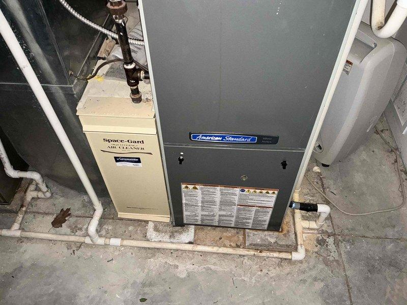 Completed full HVAC system replacement due to cracked heat exchanger in existing furnace. Installed new American Standard furnace with proper PVC venting and condensate drainage, along with Space-Gard air cleaner system. Presented multiple system options to address failed equipment and ensure safe, efficient heating operation.