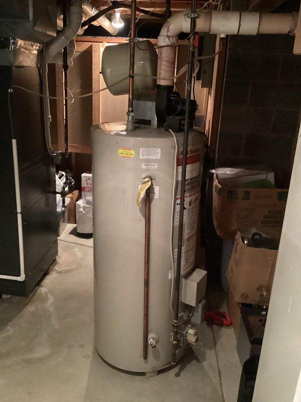 Conducted site assessment of existing water heating system in unfinished basement utility area. Documented current tank-style water heater installation, including all supply lines, venting configuration, and available space for potential equipment upgrade. Photographed existing plumbing connections, gas lines, and surrounding mechanical systems to provide accurate quote for replacement options including traditional tank water heater and tankless water heater alternatives.