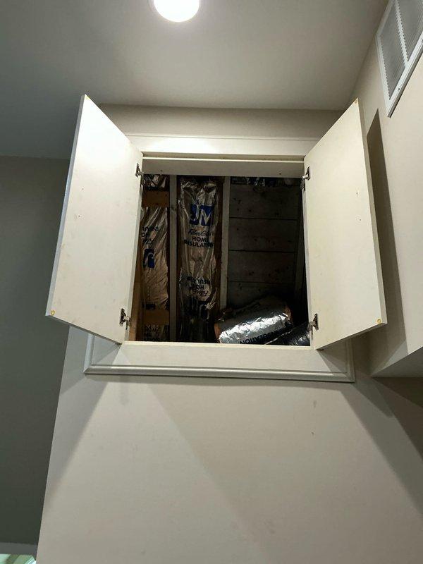Conducted site evaluation for heat pump and air handler replacement options. Assessed existing mechanical access cabinet and ductwork configuration in utility space, documenting current system layout and installation conditions. Photographed exterior unit location area including foundation access points and drainage conditions to determine optimal equipment placement for replacement system.
