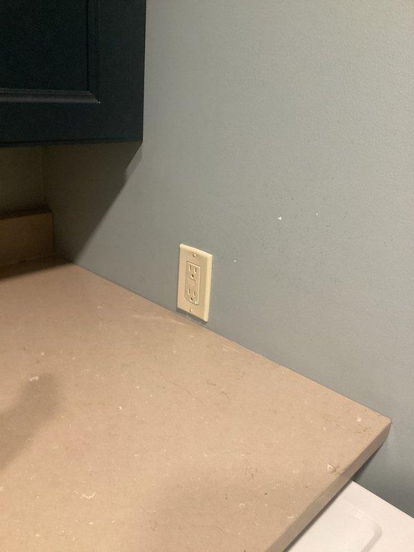 Separated a standard electrical outlet from GFCI protection and installed a new independent receptacle. Installed outlet above countertop in kitchen area with proper wall plate, and added a second outlet in adjacent room with blue-gray textured wall covering near baseboard trim. Both receptacles were properly wired, tested for correct polarity and grounding, and verified to be functioning safely per NEC standards.