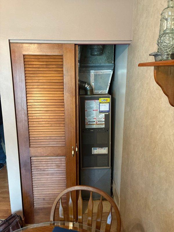 Conducted comprehensive HVAC system evaluation for full replacement options at residential property. Assessed existing vertical air handler unit located in interior utility closet with bi-fold louvered door access. Documented current equipment configuration including ductwork connections and unit specifications. Evaluated existing Honeywell programmable thermostat showing operational status at time of visit. Provided customer with complete system replacement options and specifications for new equipment installation. Photographed existing equipment and control locations for proposal documentation.