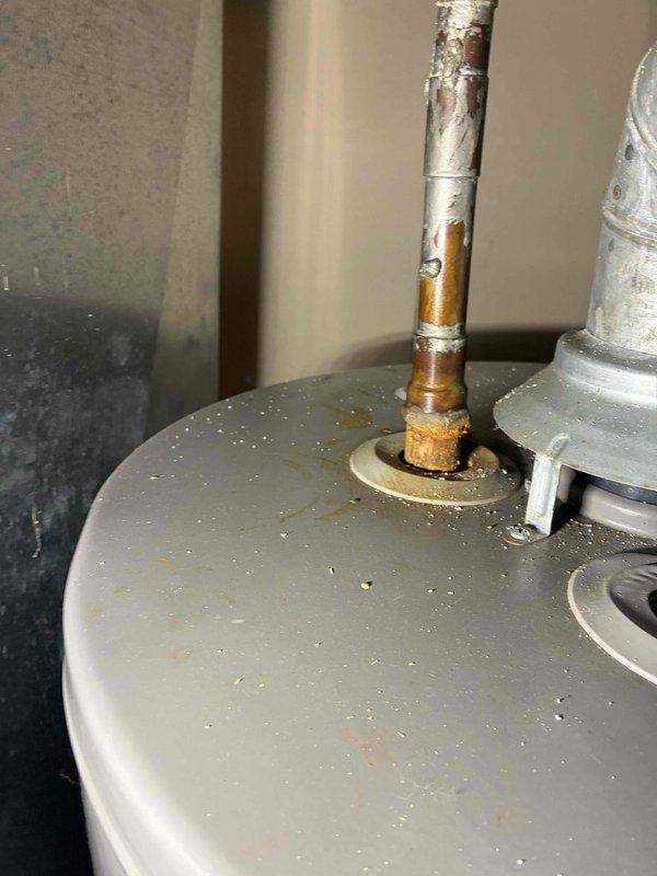 Completed comprehensive cooling system maintenance on 5/8-ton unit, including inspection of ventilation components and airflow verification. Performed concurrent hot water heater maintenance, noting copper pipe corrosion at tank connection point and documenting existing condition of unit with accumulated dust on tank surface.