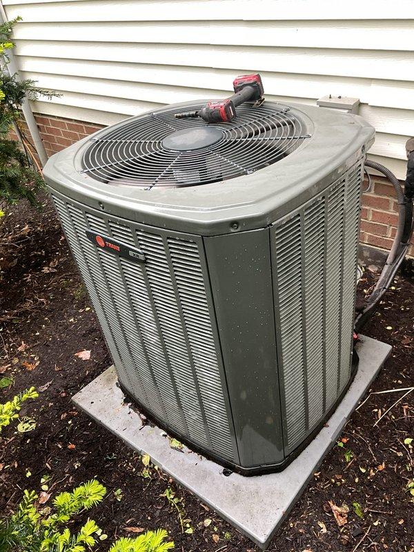 Completed preventative maintenance service on two residential air conditioning systems. Performed comprehensive inspection of both outdoor condensing units, including a white-housed unit and a Trane condenser with gray/green casing. Inspected fan motors, compressors, and electrical components on both systems. Checked refrigerant levels, verified proper operation of capacitors, and examined all electrical connections for security and signs of wear. Cleaned condenser coils and removed debris accumulation from base areas and surrounding concrete pads. Verified proper airflow through louvered panels and fan guards. Both systems tested and confirmed operational with normal performance parameters.